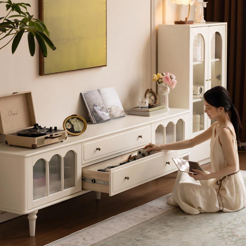 Angled view of Emily TV console showing arched glass doors, drawers, and open shelving in a living room