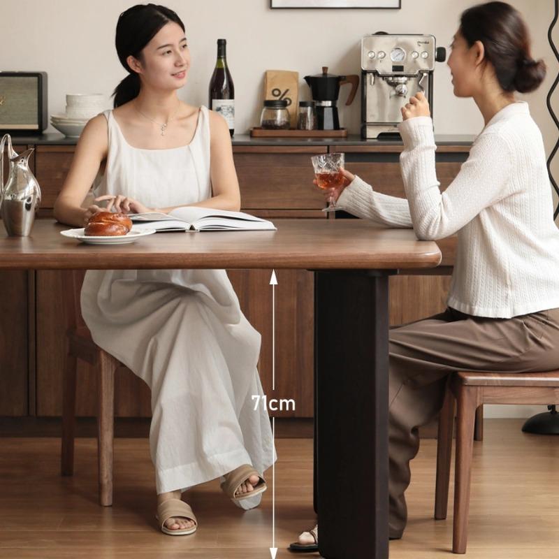 Osta large dining table in black walnut, lifestyle shot with two people dining together