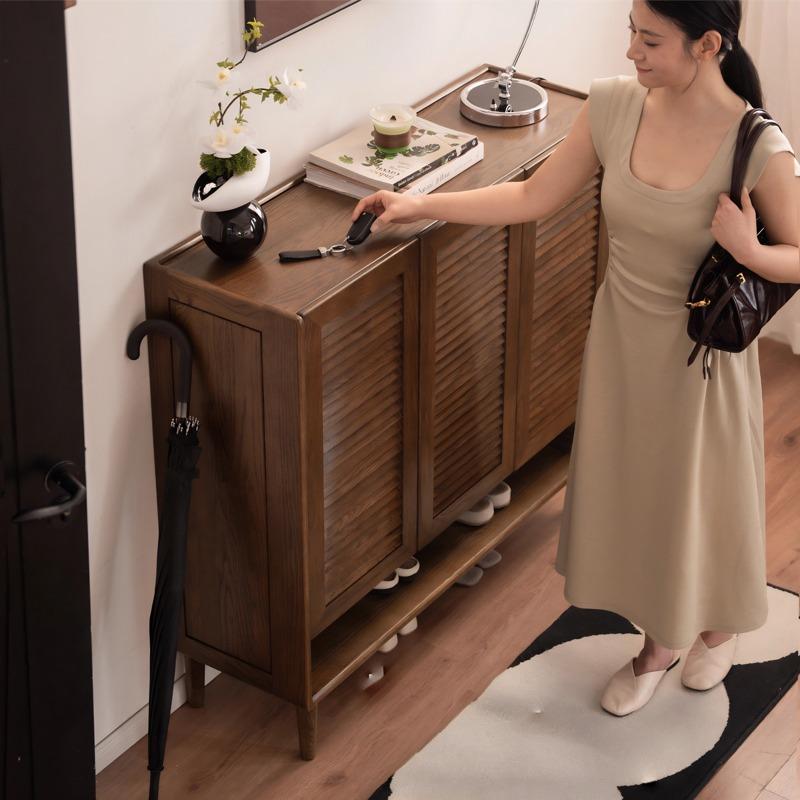 Vivian shoe rack styled in a home entryway with decor on top surface and shoes on bottom shelf