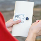 Portable folder in cream, lifestyle shot showing the folder held in hands outdoors