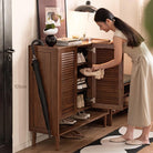 Person placing shoes into the Vivian shoe rack in an entryway setting